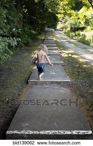 Caucasian boy climbing stairs near rural path View Large Photo Image Stock Image - Caucasian boy climbing stairs near rural path. Fotosearch