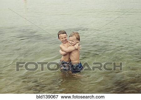 Caucasian boys hugging in lake View Large Photo Image Stock Photo - Caucasian boys hugging in lake. Fotosearch