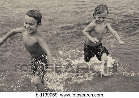Caucasian boys playing in lake View Large Photo Image Stock Photo - Caucasian boys playing in lake. Fotosearch
