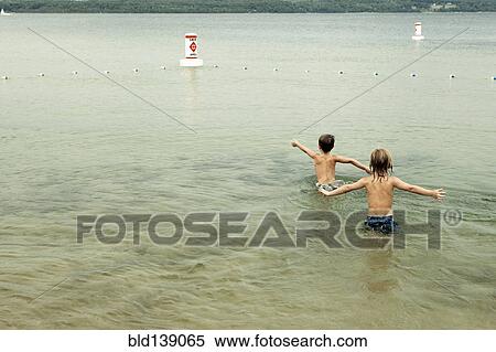 Stock Photography - Caucasian boys swimming in lake. Fotosearch