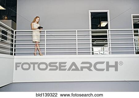 Stock Image - Caucasian businesswoman using digital tablet railing. Fotosearch