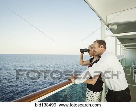 Stock Photo - Caucasian couple admiring view from boat deck. Fotosearch