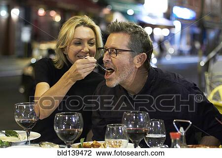 Stock Image - Caucasian couple eating at urban cafe, New York City, New York, United States. Fotosearch