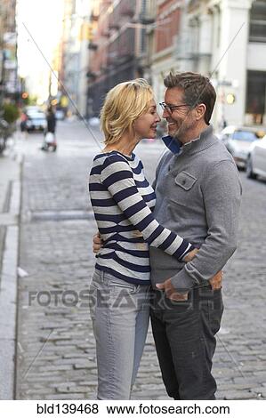 Stock Photo - Caucasian couple hugging on city street, New York City, New York, United States. Fotosearch