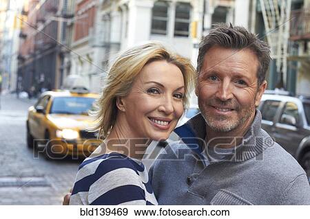 Stock Photo - Caucasian couple hugging on city street, New York City, New York, United States. Fotosearch