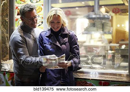 Stock Photography - Caucasian couple reading menu at food cart, New York City, New York, United States. Fotosearch
