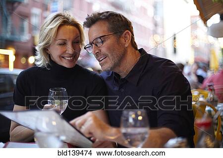 Caucasian couple reading menu at urban cafe, New York City, New York, United States View Large Photo Image Picture - Caucasian couple reading menu at urban cafe, New York City, New York, United States. Fotosearch