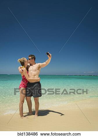 Caucasian couple taking selfie on tropical beach View Large Photo Image Stock Photograph - Caucasian couple taking selfie on tropical beach. Fotosearch