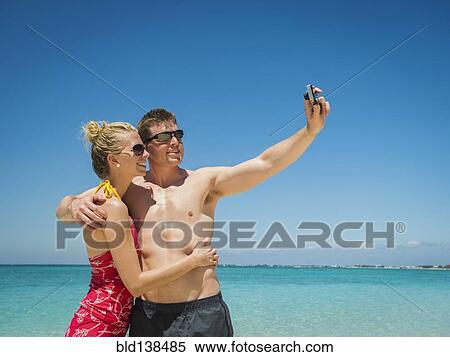 Caucasian couple taking selfie on tropical beach View Large Photo Image Stock Photography - Caucasian couple taking selfie on tropical beach. Fotosearch
