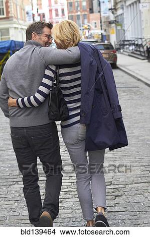 Picture - Caucasian couple walking on city street, New York City, New York, United States. Fotosearch
