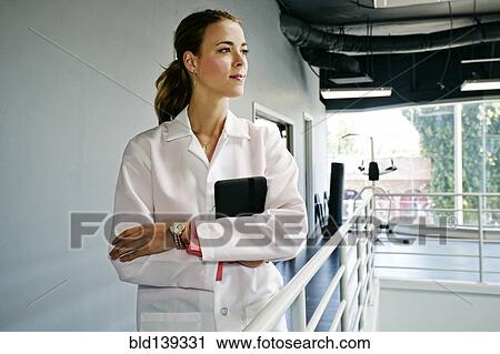 Caucasian doctor holding digital tablet near railing View Large Photo Image Stock Image - Caucasian doctor holding digital tablet near railing. Fotosearch
