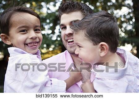 Caucasian father holding sons outdoors View Large Photo Image Stock Photography - Caucasian father holding sons outdoors. Fotosearch