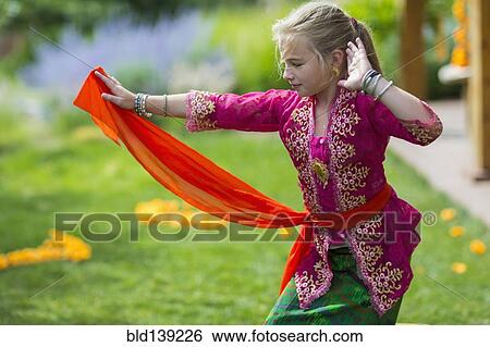 Caucasian girl performing Balinese dance in backyard View Large Photo Image Stock Photograph - Caucasian girl performing Balinese dance in backyard. Fotosearch