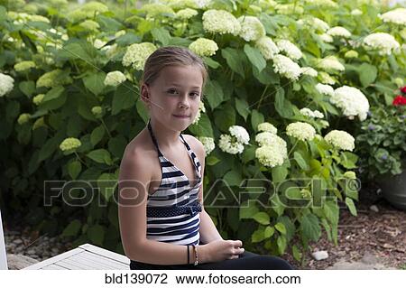 Stock Image - Caucasian girl sitting outdoors. Fotosearch