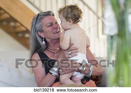 Stock Photo - Caucasian grandmother holding grandson outdoors. Fotosearch