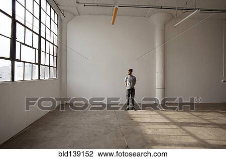 Caucasian man standing in empty loft View Large Photo Image Stock Image - Caucasian man standing in empty loft. Fotosearch