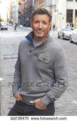 Stock Image - Caucasian man standing on city street, New York City, New York, United States. Fotosearch