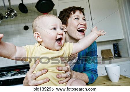 Caucasian mother and baby relaxing in kitchen View Large Photo Image Stock Photography - Caucasian mother and baby relaxing in kitchen. Fotosearch