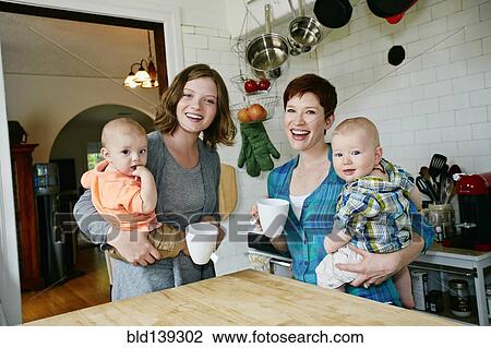 Caucasian mothers holding babies in kitchen View Large Photo Image Stock Image - Caucasian mothers holding babies in kitchen. Fotosearch