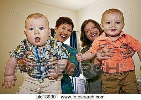 Stock Image - Caucasian mothers holding babies. Fotosearch