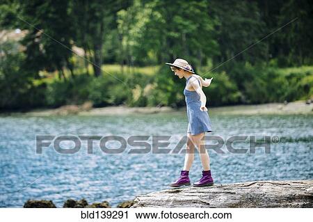 Caucasian woman walking on rock near river View Large Photo Image Stock Image - Caucasian woman walking on rock near river. Fotosearch