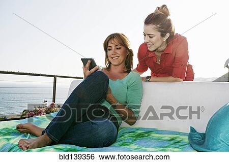 Caucasian women using digital tablet at waterfront View Large Photo Image Stock Photograph - Caucasian women using digital tablet at waterfront. Fotosearch