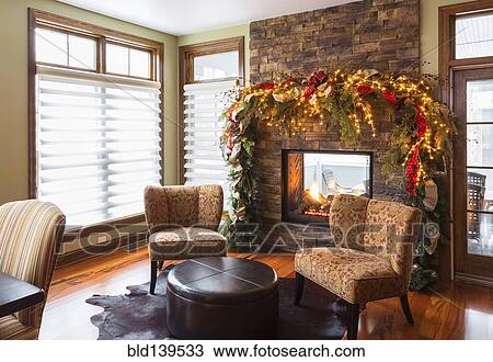 Christmas boughs and mantle with armchairs and fireplace in living room View Large Photo Image Stock Image - Christmas boughs and mantle with armchairs and fireplace in living room. Fotosearch