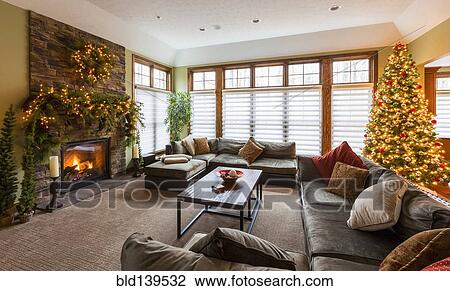 Stock Image - Christmas tree and mantle with sofas and fireplace in living room. Fotosearch