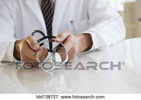 Close up of mixed race doctor holding stethoscope View Large Photo Image Stock Photo - Close up of mixed race doctor holding stethoscope. Fotosearch