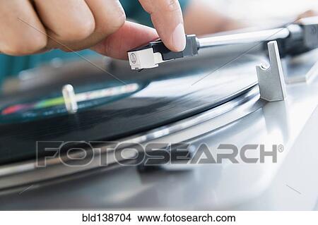 Close up of mixed race man playing vinyl record View Large Photo Image Picture - Close up of mixed race man playing vinyl record. Fotosearch