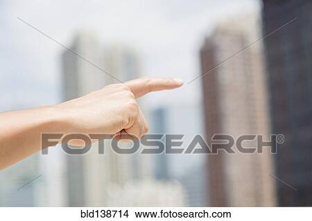 Picture - Close up of mixed race man pointing to city skyline. Fotosearch