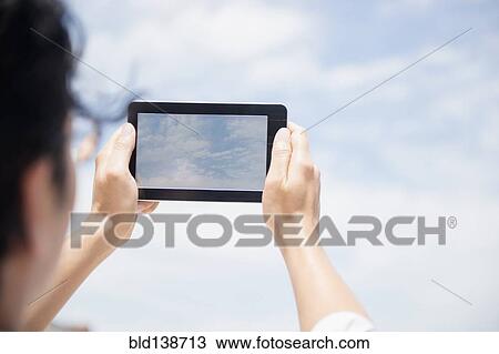 Close up of mixed race man photographing clouds with digital tablet View Large Photo Image Stock Image - Close up of mixed race man photographing clouds with digital tablet. Fotosearch