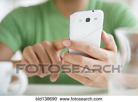 Stock Image - Close up of mixed race man using cell phone. Fotosearch