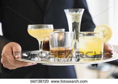 Close up of mixed race waiter holding tray of drinks View Large Photo Image Stock Image - Close up of mixed race waiter holding tray of drinks. Fotosearch