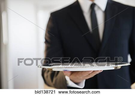 Close up of mixed race waiter holding empty tray View Large Photo Image Stock Image - Close up of mixed race waiter holding empty tray. Fotosearch