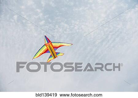 Stock Photo - Colorful airplane kite flying in blue sky. Fotosearch