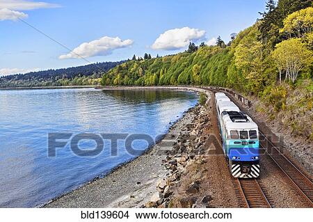 Commuter train on tracks at waterfront View Large Photo Image Picture - Commuter train on tracks at waterfront. Fotosearch