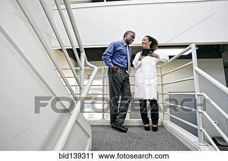 Doctor and businessman using digital tablet together View Large Photo Image Stock Image - Doctor and businessman using digital tablet together. Fotosearch