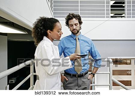 Doctor and businessman using digital tablet together View Large Photo Image Stock Image - Doctor and businessman using digital tablet together. Fotosearch