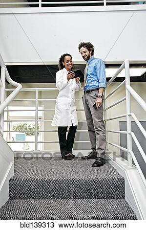 Doctor and businessman using digital tablet together View Large Photo Image Stock Image - Doctor and businessman using digital tablet together. Fotosearch