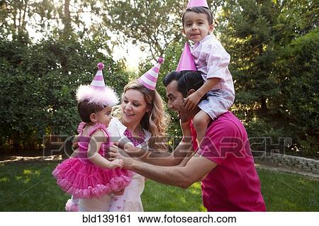 Family wearing party hats together in backyard View Large Photo Image Stock Image - Family wearing party hats together in backyard. Fotosearch