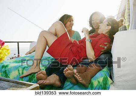 Stock Image - Friends playing together at waterfront. Fotosearch