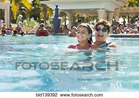 Grandmother and granddaughter playing in swimming pool View Large Photo Image Stock Image - Grandmother and granddaughter playing in swimming pool. Fotosearch
