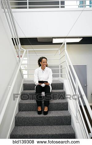 Hispanic doctor holding digital tablet on staircase View Large Photo Image Stock Photo - Hispanic doctor holding digital tablet on staircase. Fotosearch