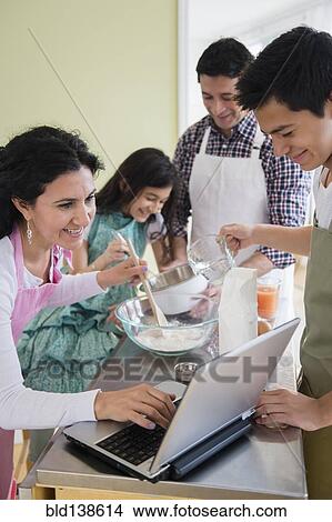 Picture - Hispanic family baking in kitchen. Fotosearch