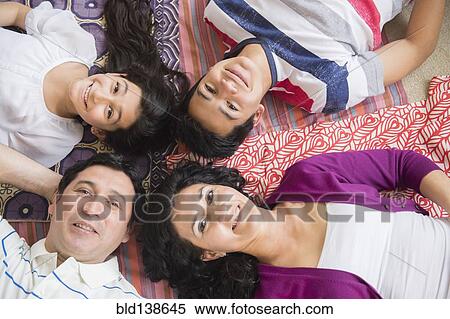 Stock Photography - Hispanic family laying together on blankets. Fotosearch