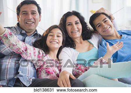 Hispanic family smiling together on sofa View Large Photo Image Stock Image - Hispanic family smiling together on sofa. Fotosearch