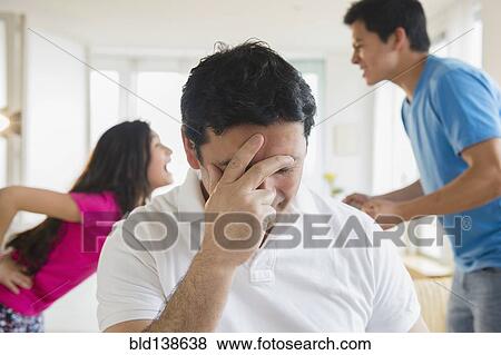 Hispanic father covering his face as children fight behind him View Large Photo Image Stock Photo - Hispanic father covering his face as children fight behind him. Fotosearch