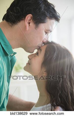 Hispanic father kissing daughter on forehead View Large Photo Image Stock Photo - Hispanic father kissing daughter on forehead. Fotosearch