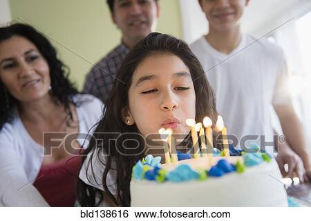 Hispanic girl blowing out candles on birthday cake View Large Photo Image Stock Photograph - Hispanic girl blowing out candles on birthday cake. Fotosearch